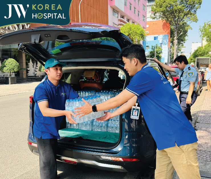 nhân viên bệnh viện JW hỗ trợ bưng nước suối cứu trợ miền Trung